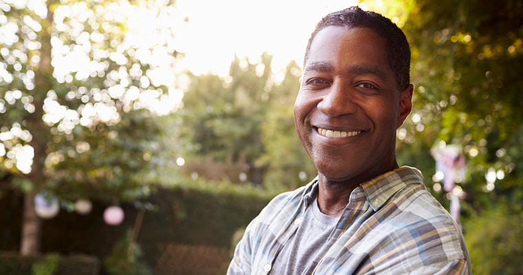 A man in a checkered shirt smiling happily