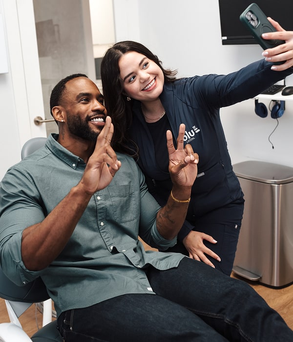 Enhance Your Smile with Safe, Effective Teeth Whitening. A man is smiling and making selfie with his Blu Dental dentist
