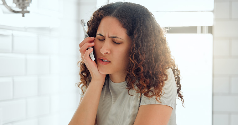 A woman holding her jaw in pain