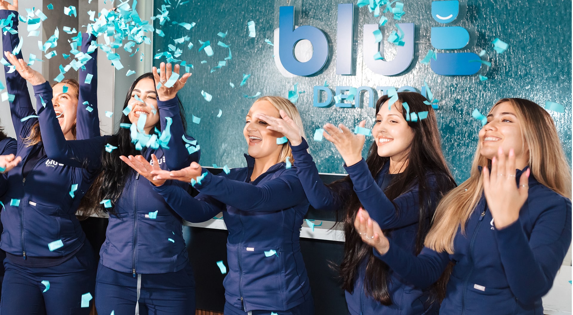 Blu dental team having fun and smiling at front desk