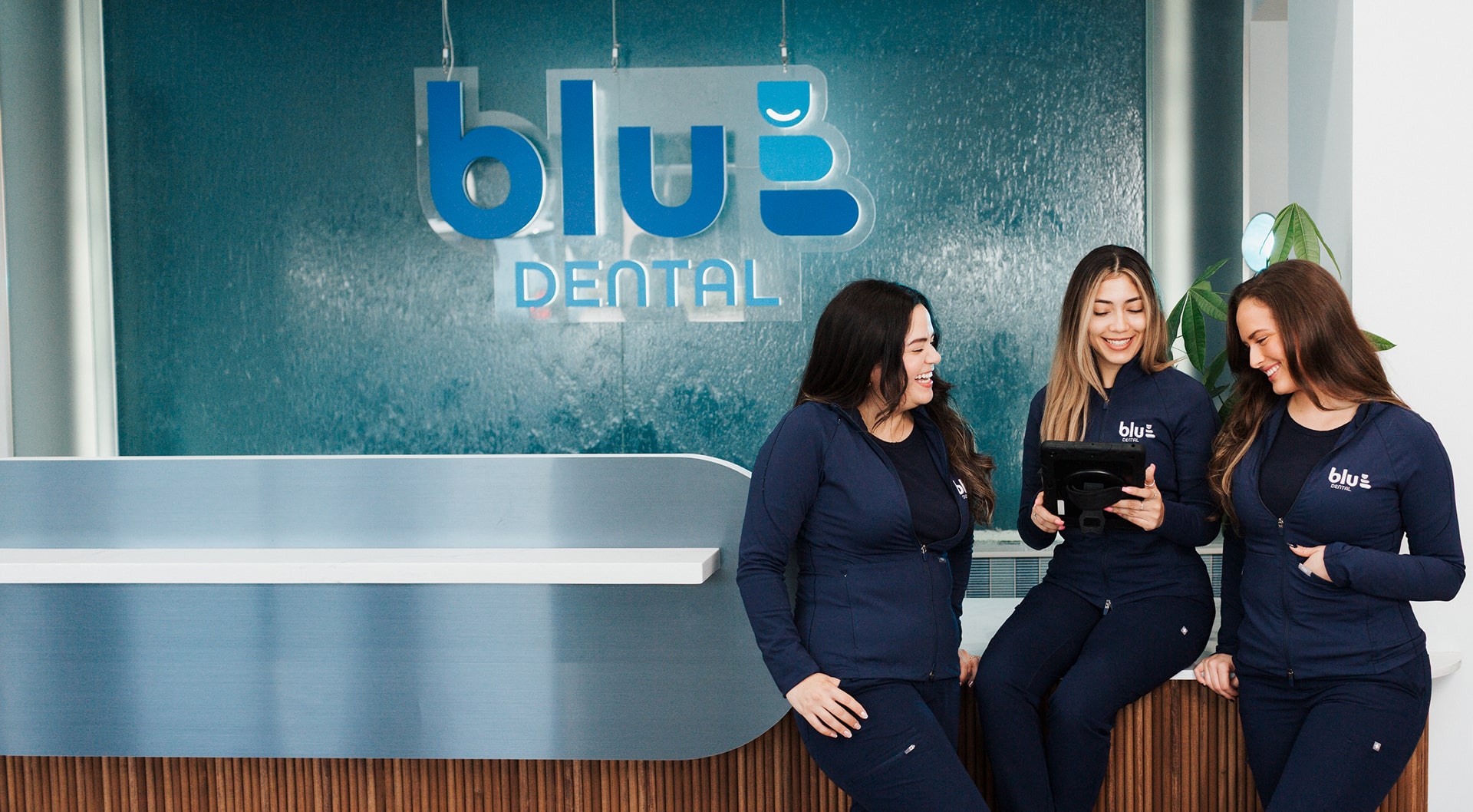 Blu Dental team is smiling at front desk