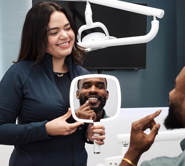 Dental Implants That Look & Feel Like Real Teeth. Dentist is joyfully smiling with her patient