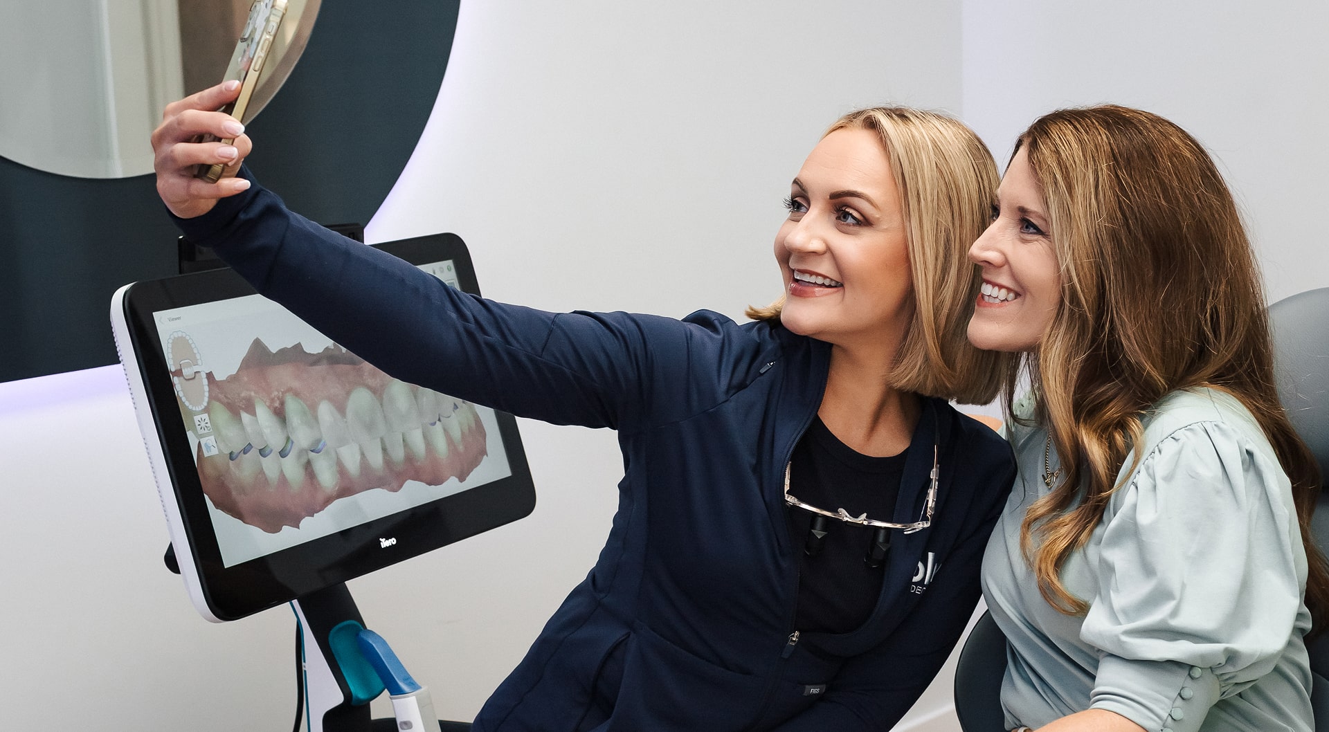 Dentist is making slfie with a happy smiling patient in a dental chair