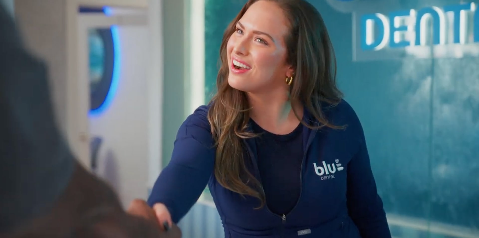 Top dentist is shaking hands with a patent and smiling