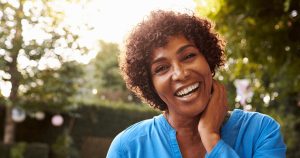 A female smiles after her dentures procedure.