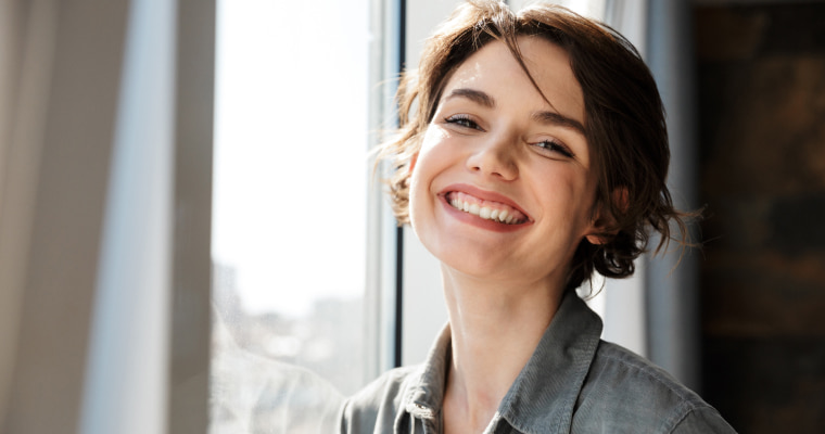 A woman smiling after her dental treatment