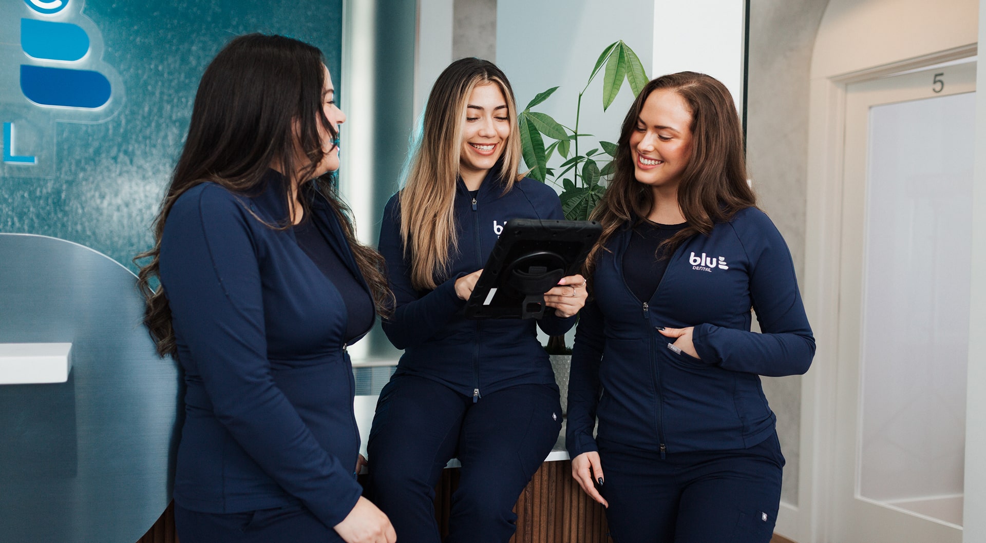 Meet Your Dentist Online – Here’s How. Blu Dental Team is smiling with a tablet in hands