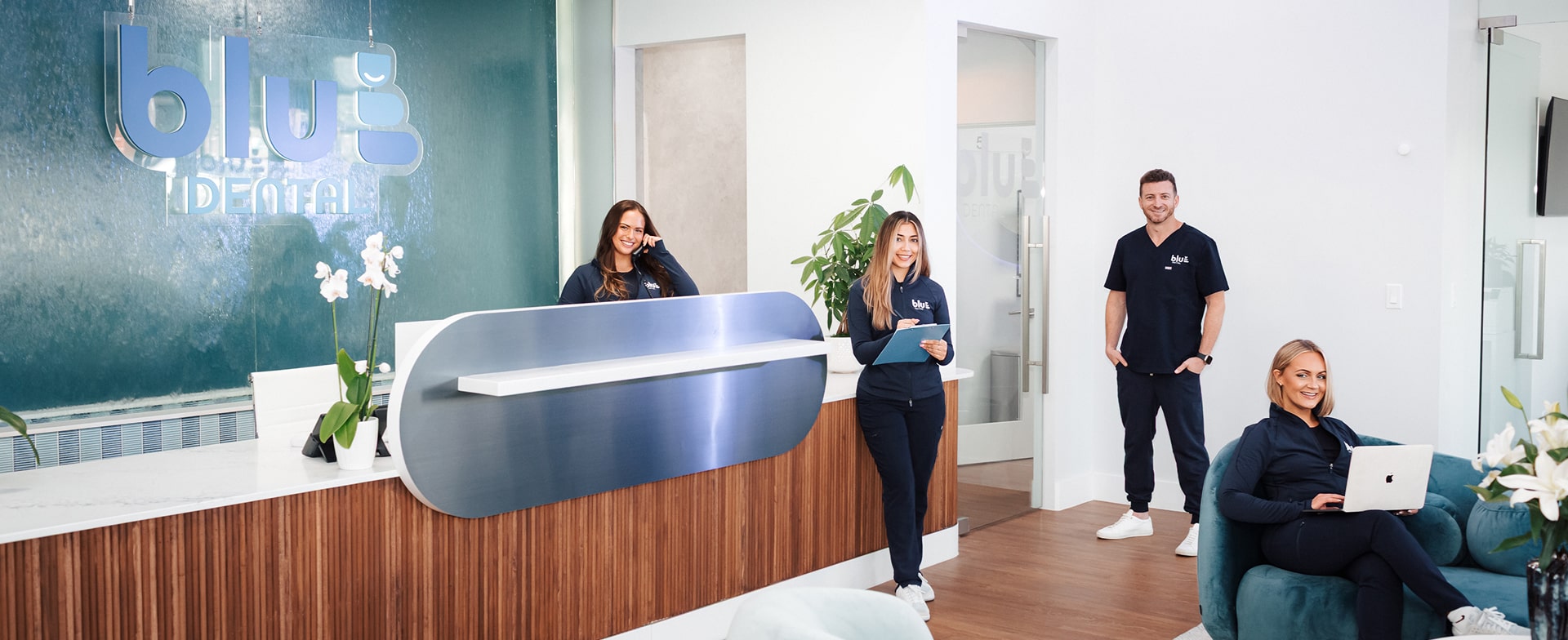 Quick, Easy Dental Visits Without the Wait. Blu Dental team smiling at front desk