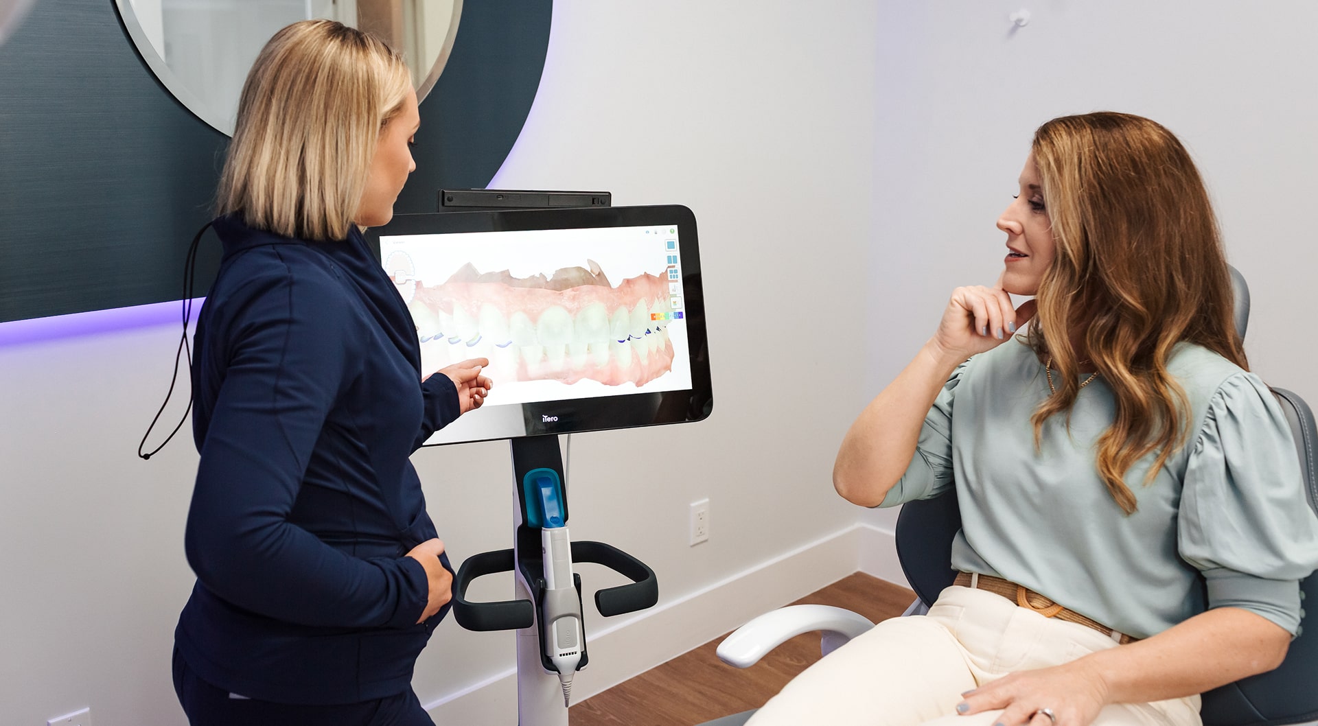 Blu dental expert consulting smiling patient in a dental chair