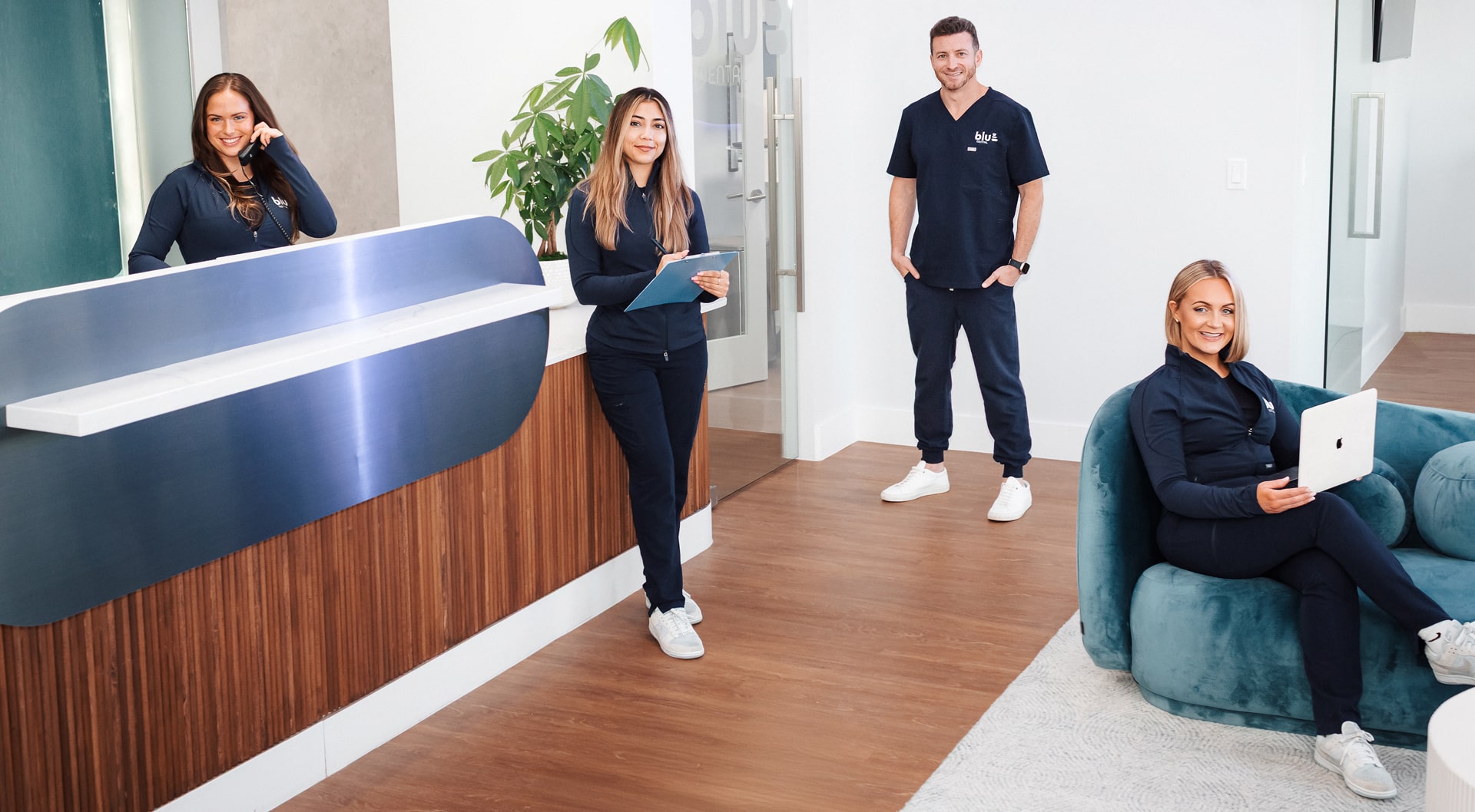 Blu dental professional team is smiling at front desk