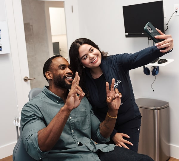 Enjoy Stress-Free Dental Care with Honest, Transparent Service. Dental expert is making selfie with a smiling patient