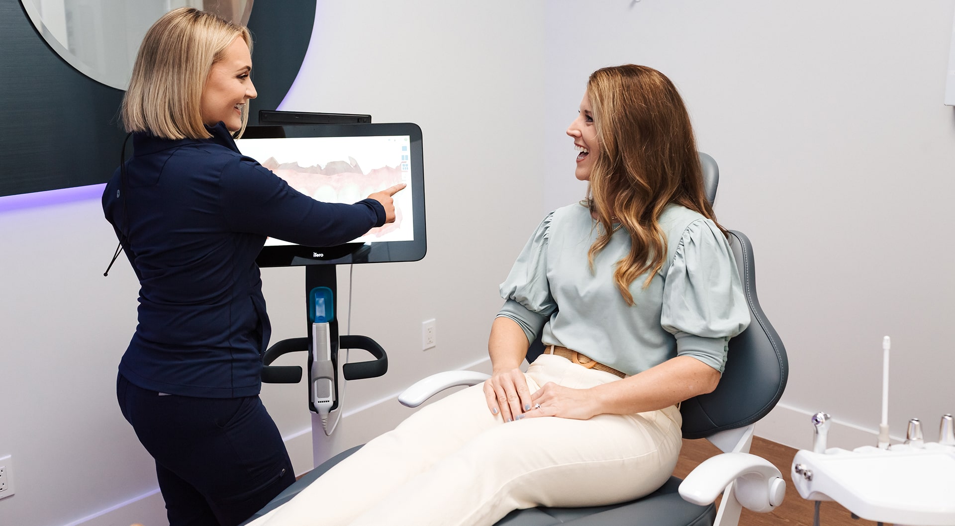 Dental professional is smiling with joyful patient in a dental chair