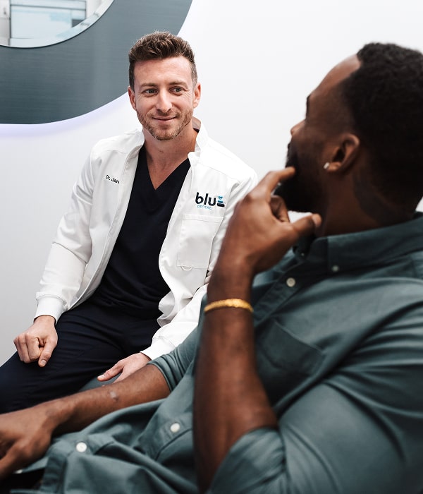Dentist is joyfully smiling with a patient in a chair