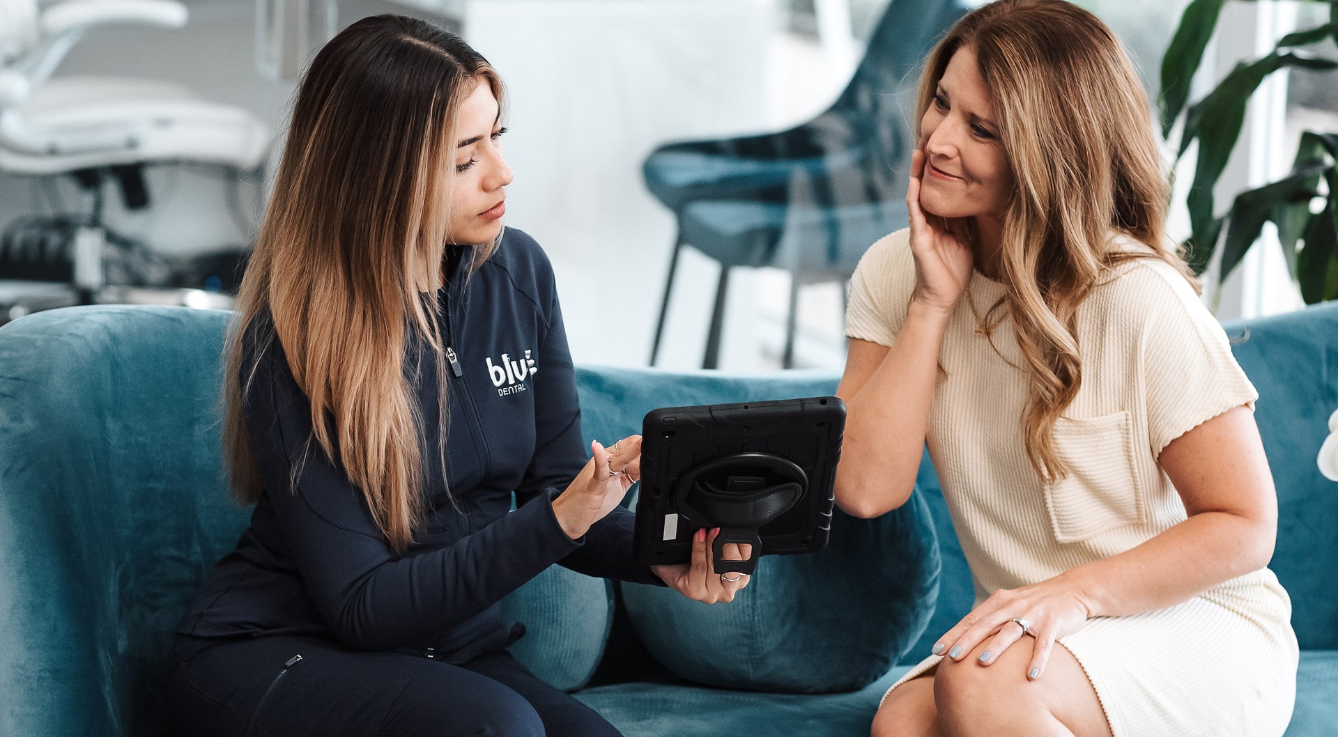 Dentist explaining smile makeover to a lightly smiling woman
