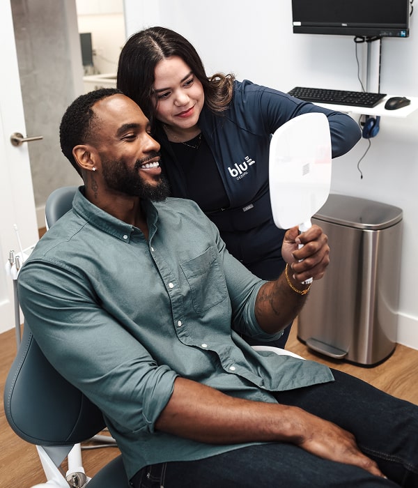 Enjoy Teeth That Look and Feel Real with Advanced Dental Solutions. Happy client with his dentist at Blu Dental office